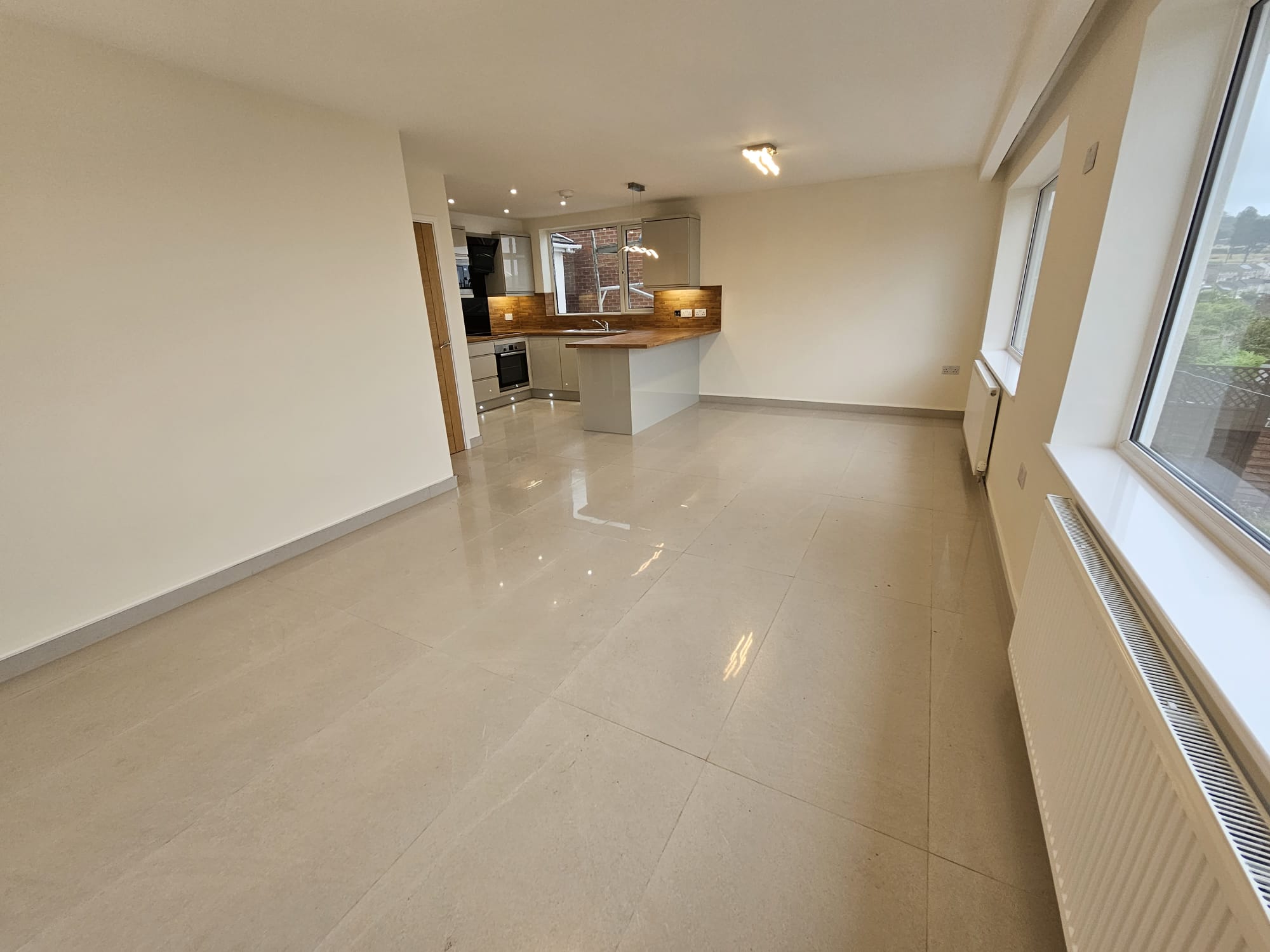 Open-plan kitchen and living room floor tiled by Laporsa