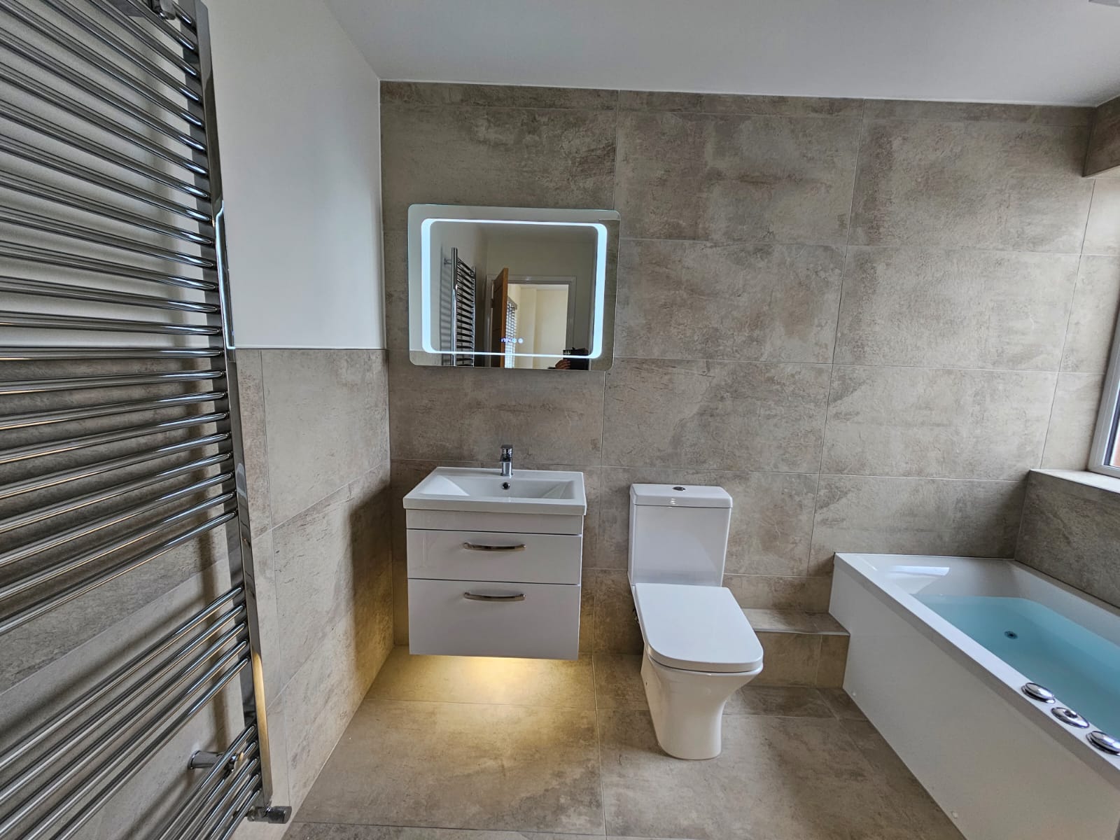 Bathroom with stone-effect wall and floor tiles, supplied and fitted by Laporsa
