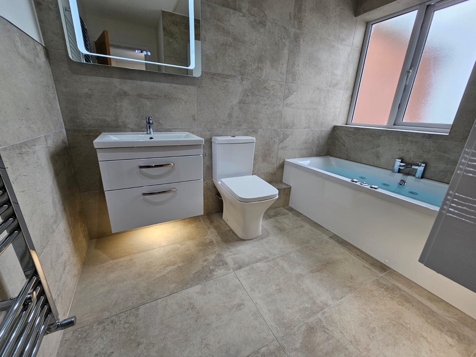 Tiled bathroom with vanity unit and bath, fitted by Laporsa
