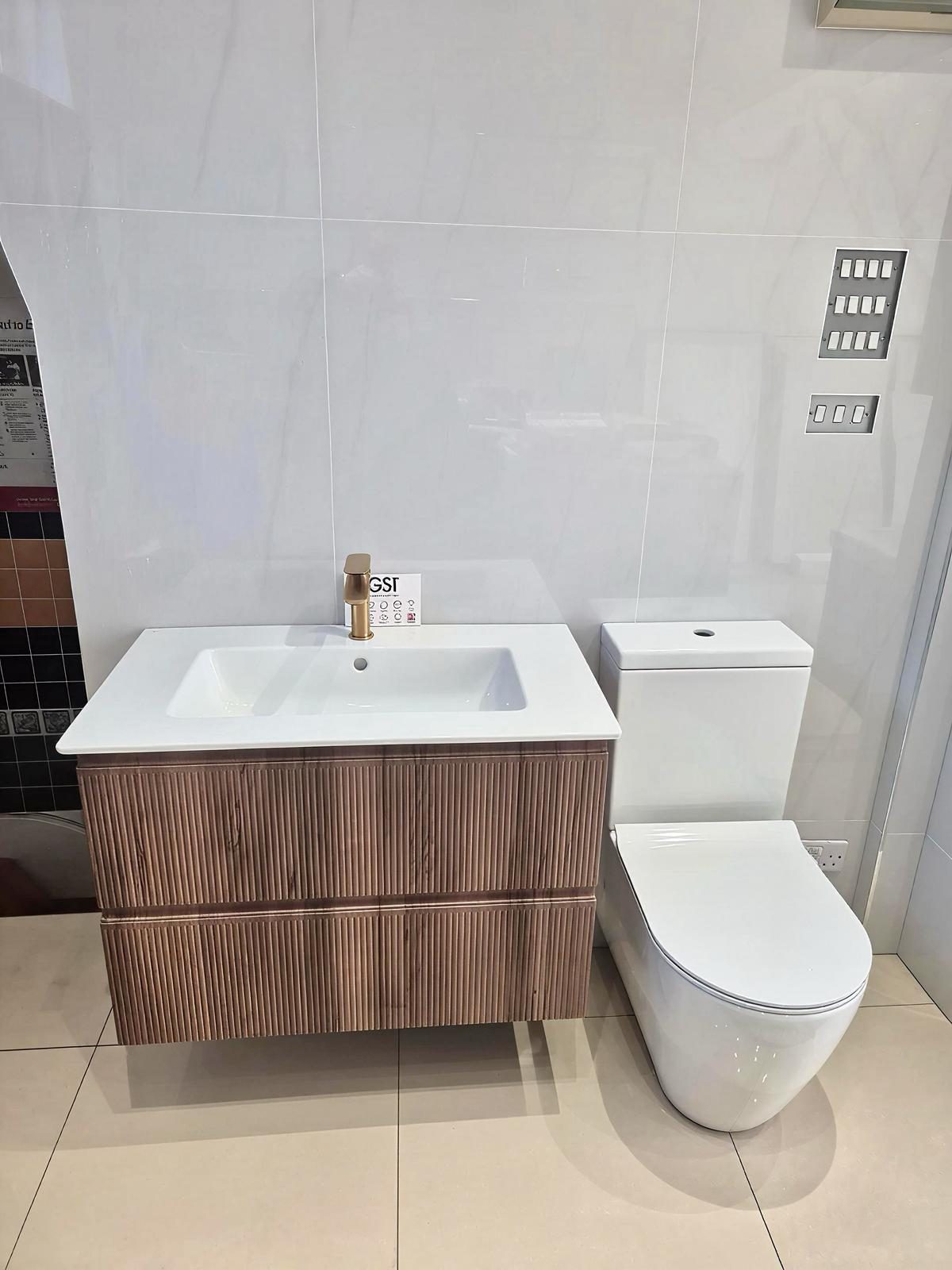 Walnut vanity with brushed brass tap and rimless toilet