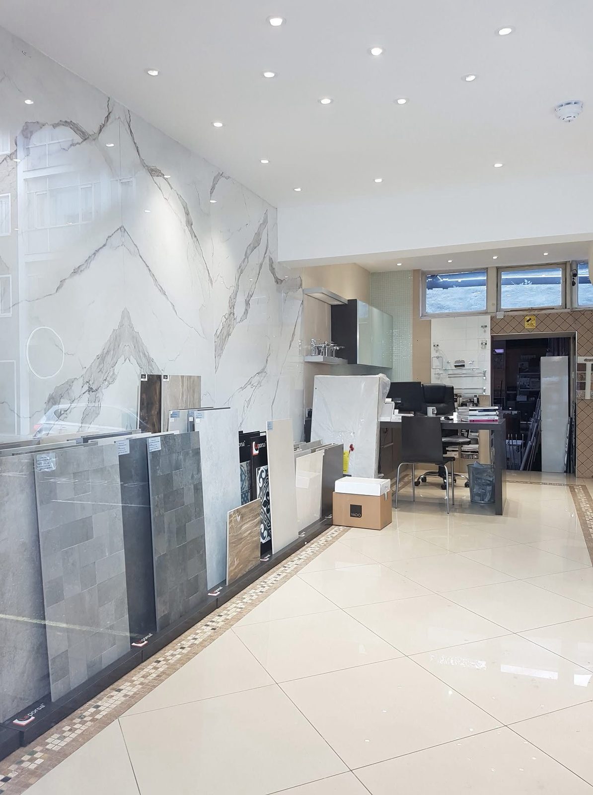 Long view of the showroom with marble-effect wall tiles and tile panels