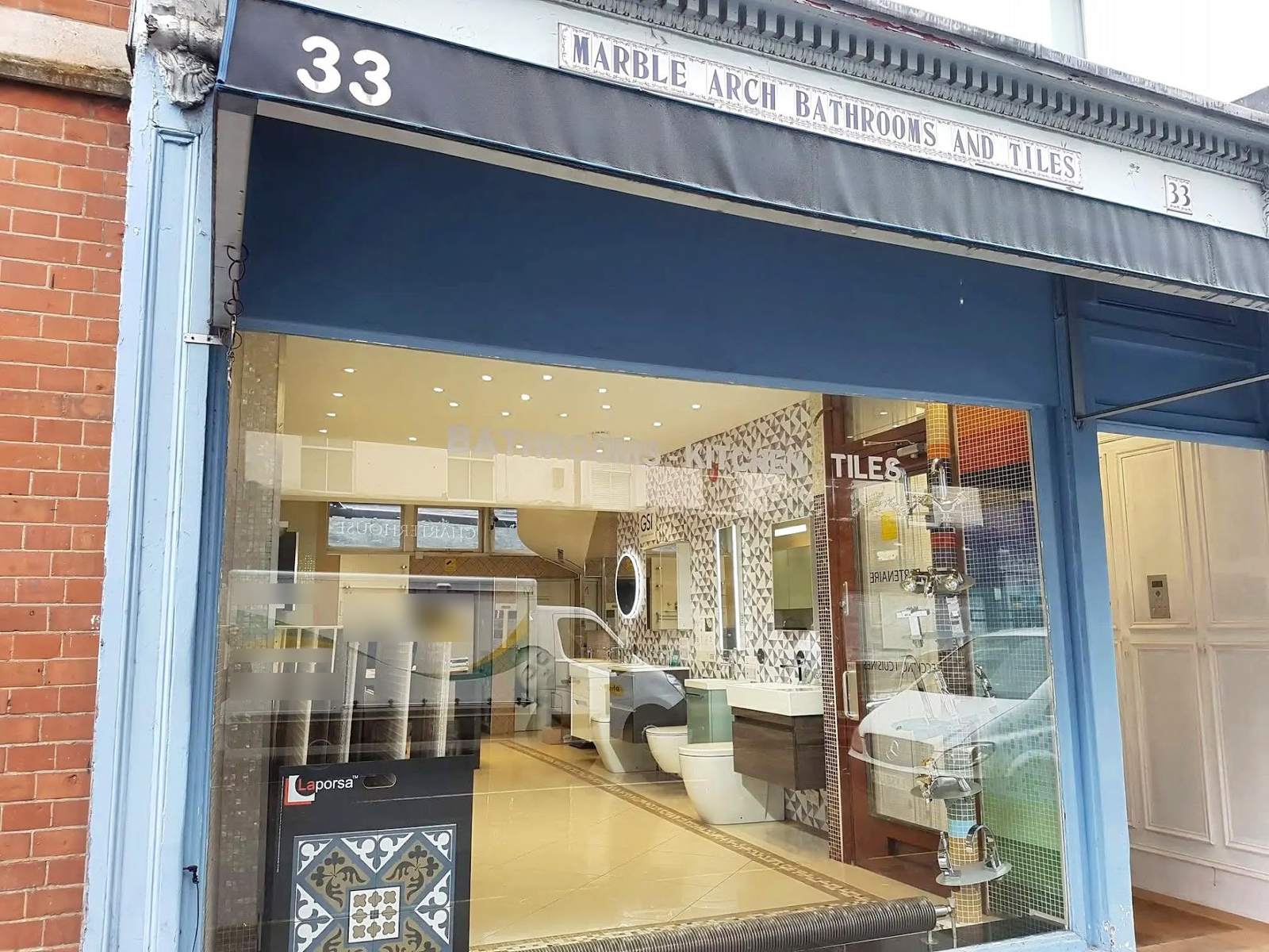 The blue shopfront of Marble Arch Bathrooms and Tiles at 33 Crawford Street
